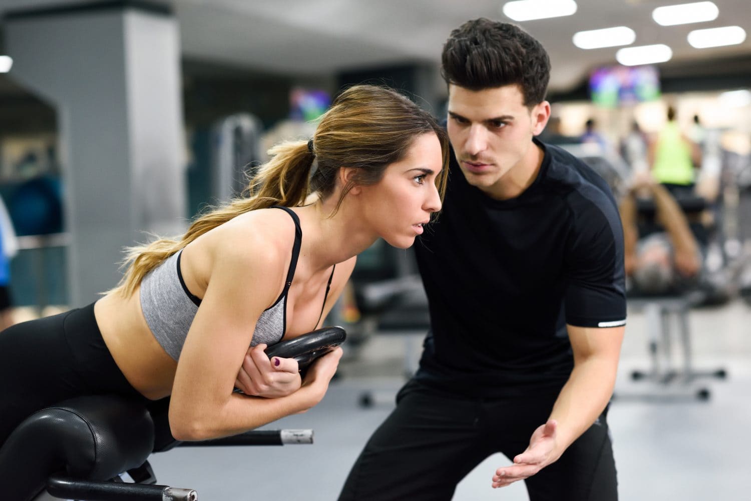 student being coached by personal trainer